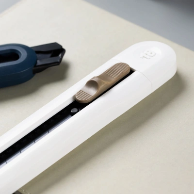 Нож канцелярский Deli ENS062-WHITE Nusign шир.лез.18мм выдвижное лезвие фиксатор 8 сменных лезвий металл/пластик белый